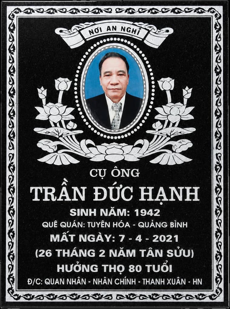 Bia mộ đá đen có ảnh chân dung và hoa văn sen trắng